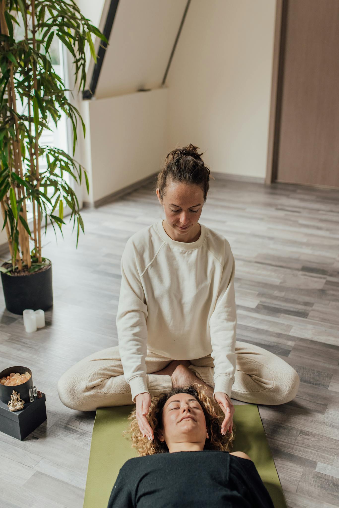 A serene Reiki healing session with a practitioner and client in a tranquil indoor space.